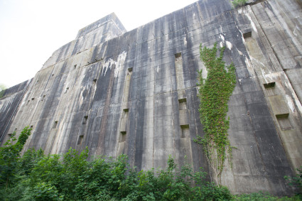 Außenseite des Bunkers, bestehend aus Beton, teileweise mit Kletterpflanzen begrünt.