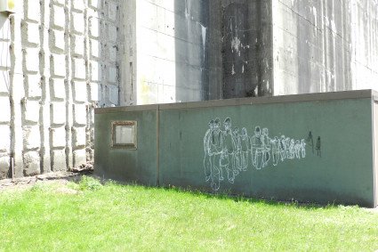 Auf einer Kreidezeichnung an der Bunkerwand sind Zwangsarbeiter abgebildet.
