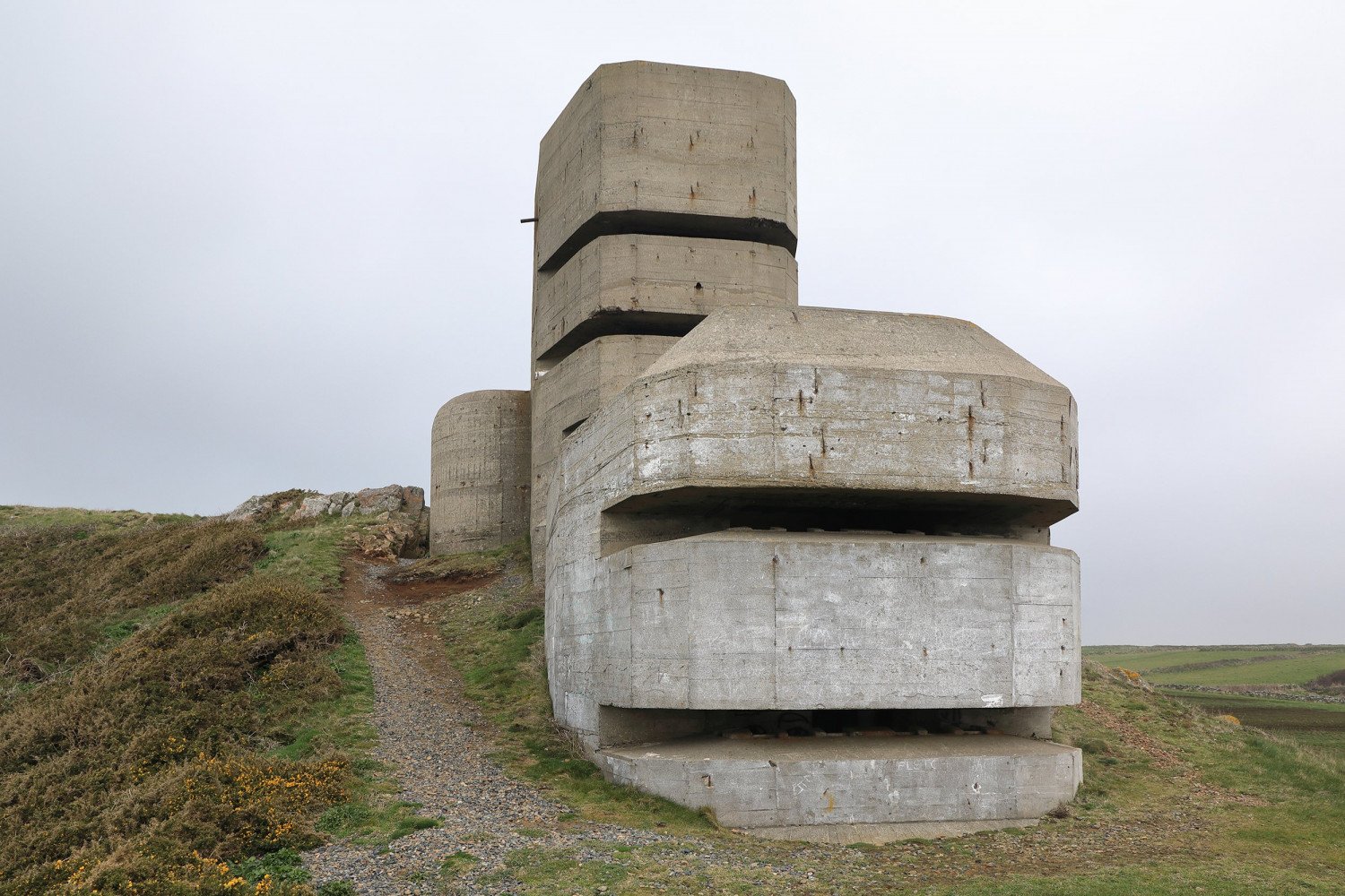 Quaderartig zusammengesetzte Betonskulptur mit waagerechten, großen Schlitzen 