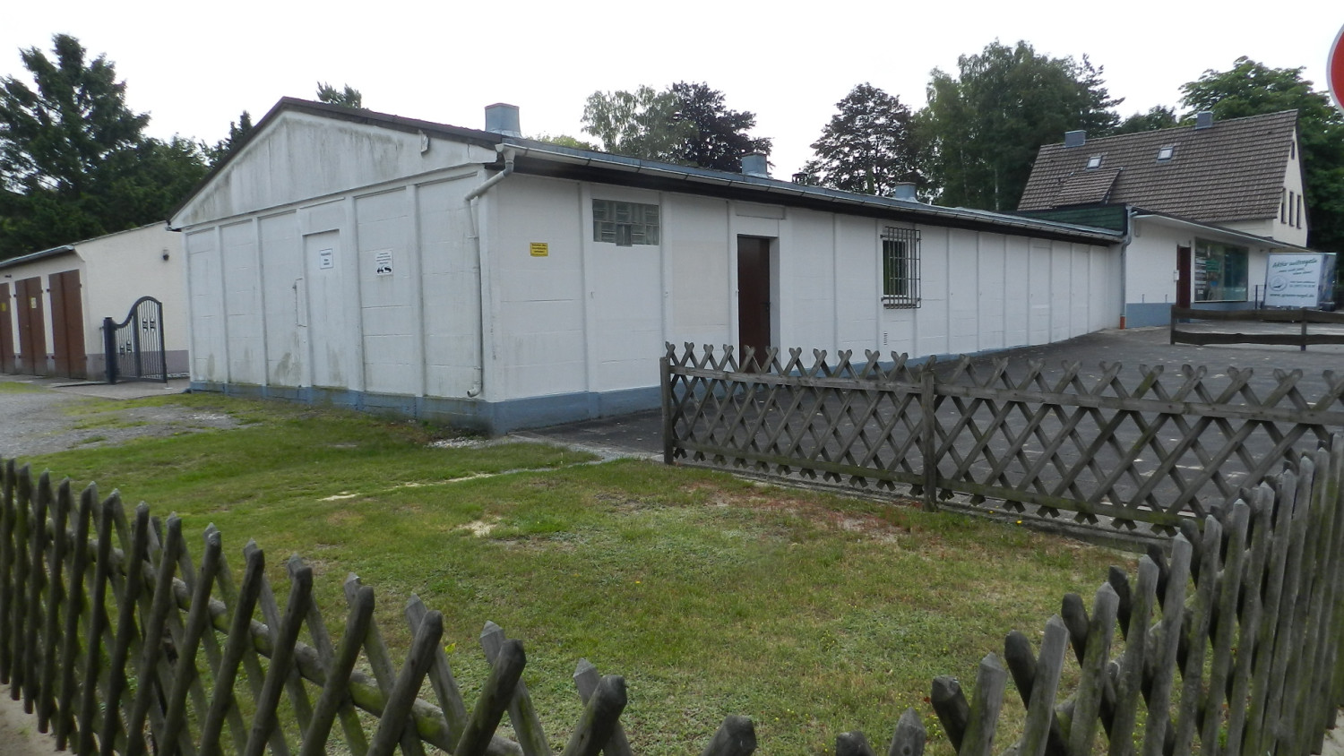 Abgebildet ist eine umzäunte Baracke.   