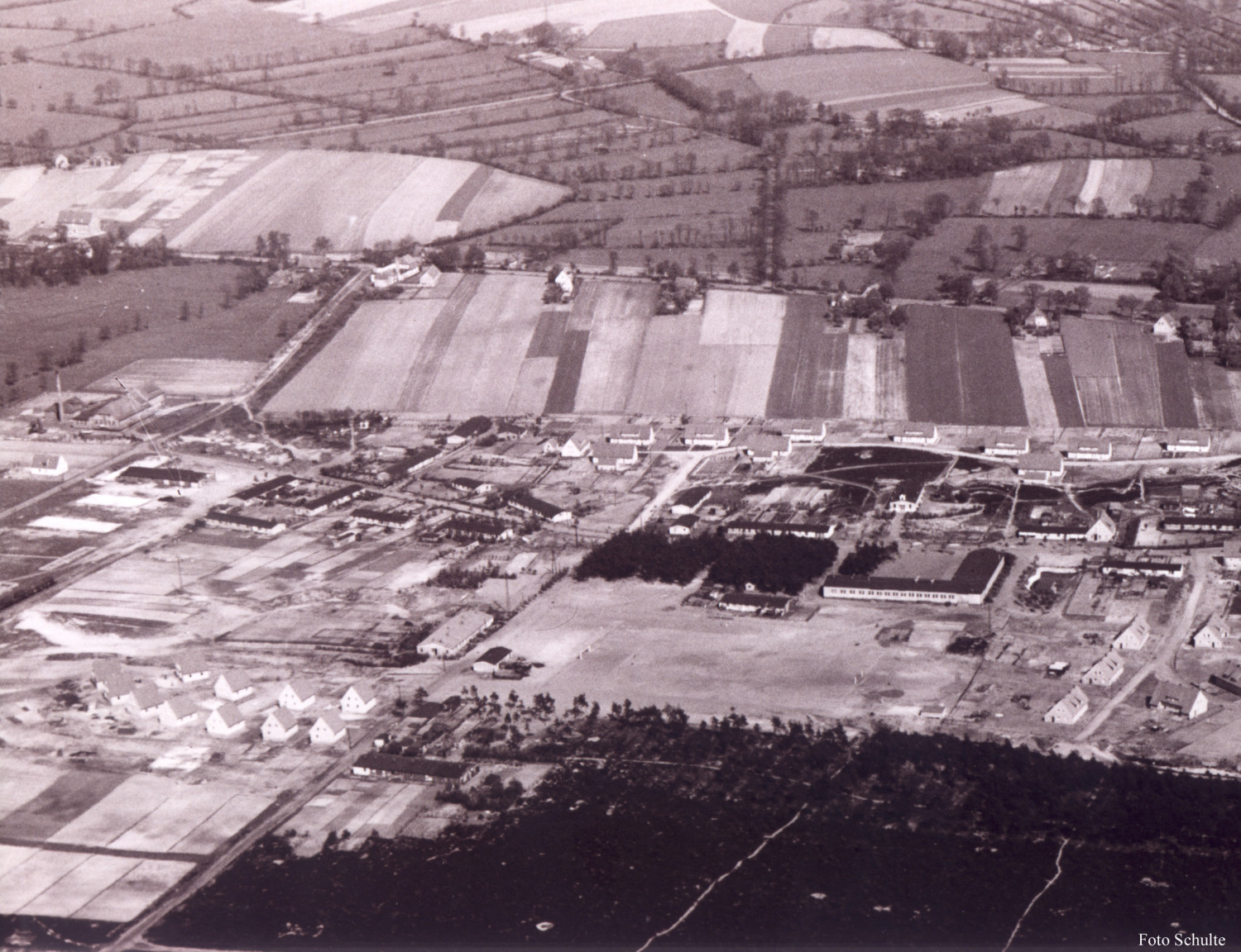 Gezeigt wird ein sepia-farbenes Bild, es ist eine Luftaufnahme von Heidkamp. 