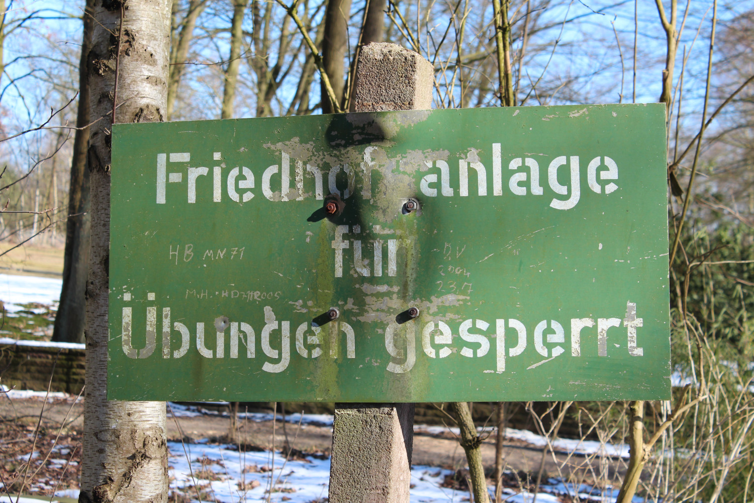 Gezeigt wird ein Bild von einem Schild mit der Inschrift "Friedhofsanlage für Übungen gesperrt" 