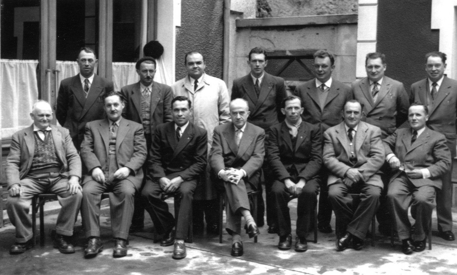 Bildnis von 14 Männern sitzend auf Stühlen, schwarz-weiss Aufnahme 