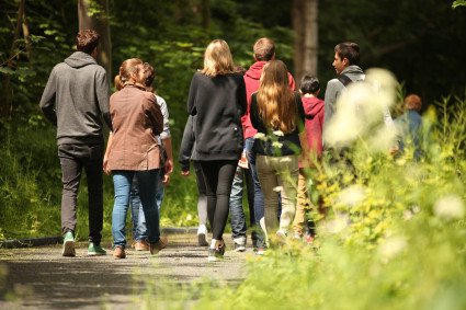 Teilnehmer:innen einer Führung gehen auf dem Rundweg.