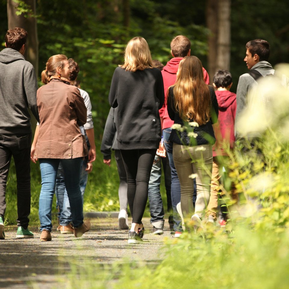 Teilnehmer:innen einer Führung gehen auf dem Rundweg.