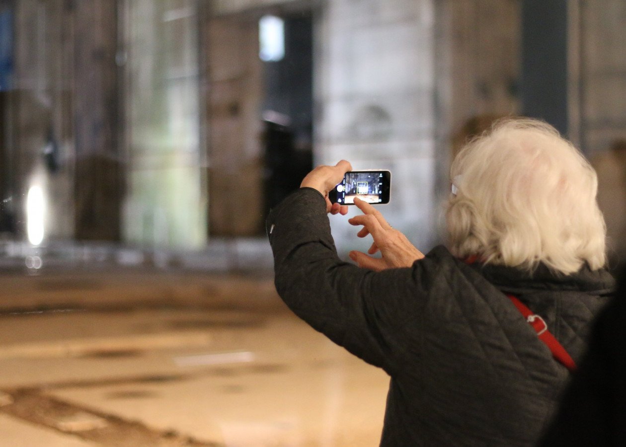 Eine Besucherin fotografiert den Ruinenteil mit ihrem Smartphone.