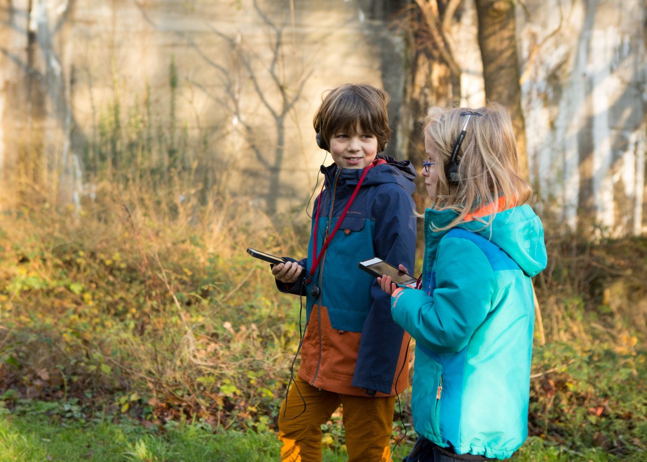 Zwei Kinder nutzen die Audioguides auf dem Rundweg.