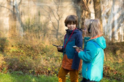 Zwei Kinder nutzen die Audioguides auf dem Rundweg.