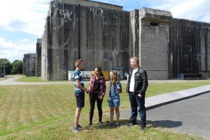 Vier Junior-Guides stehen vor dem Bunker "Valentin" und unterhalten sich.